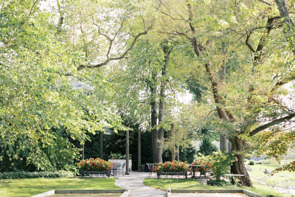 A charming outdoor venue with lush greenery and trees surrounding a pathway.
