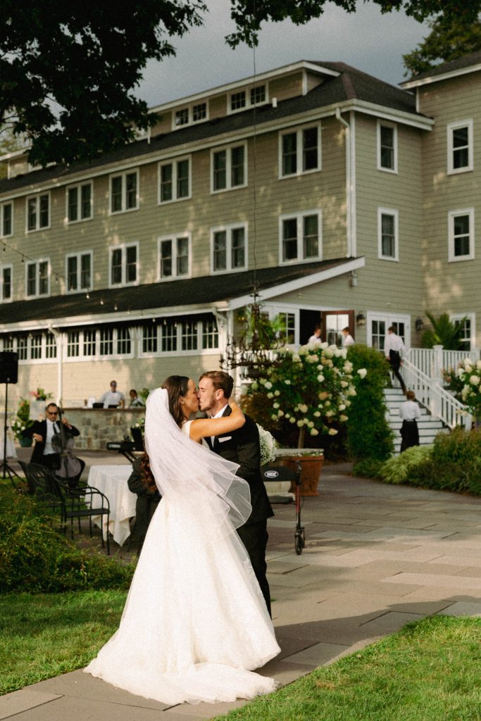 Bride and groom sharing a dance in front of a beautiful building during their wedding.