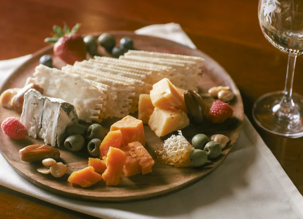 An elegant cheese and fruit platter featuring a selection of cheeses, berries, and olives.