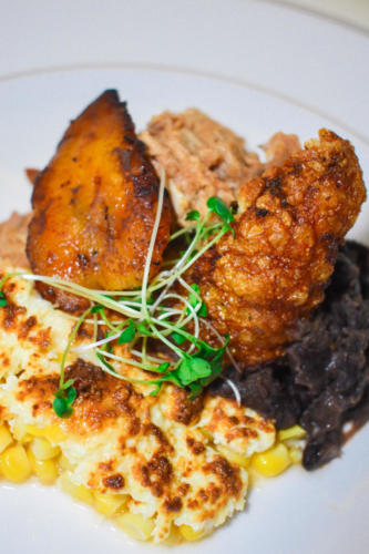 Fire pit roasted suckling pig, black beans, Mexican street corn, fried plantains, crackling
